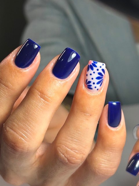 Uñas azul marino con acento floral blanco estilo talavera