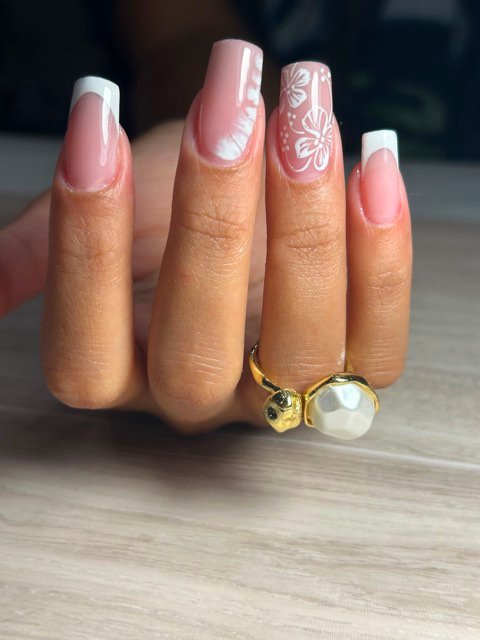 Uñas acrílicas coffin en rosa con francesa blanca y flores de hibisco
