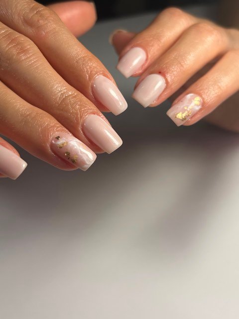 Uñas acrílicas coffin en nude con acento de mármol y hoja de oro