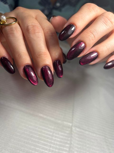 Manicura en gel efecto ojo de gato en tono vino profundo